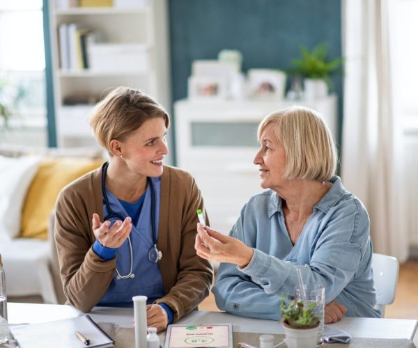 caregiver-or-healthcare-worker-with-senior-woman-patient-measuring-blood-glucose-indoors-